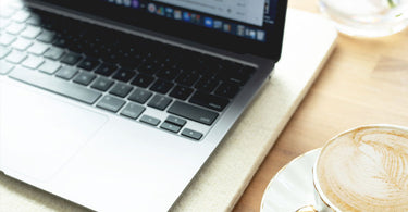 A laptop computer sits open on top of a wool pad