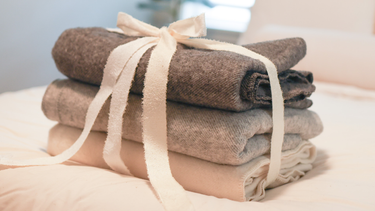 Stack of natural wool throw blankets and home textiles