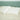 White wool pillows with natural cotton covers on teal tufted headboard, showcasing premium American-made sustainable bedding