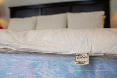 Closeup of premium Sonoma Wool Company label on natural bedding, showcasing sustainable home textiles made in Valley Ford, CA