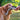 Golden retriever tugging a wool dog toy with a person's hand on the other end