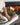 Woman ironing a shirt in front of a fireplace