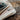 An iron resting on a wool ironing board pad and cover on a wooden table