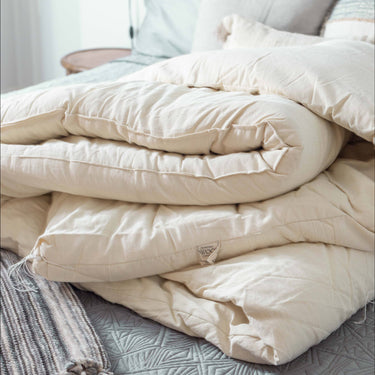 Luxurious handcrafted wool mattress topper with organic cotton casing provides exceptional pressure relief and natural temperature regulation for restorative sleep while offering an eco-friendly alternative to synthetic bedding materials