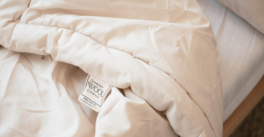 Cozy bed adorned with a soft white comforter, inviting warmth and comfort for restful sleep.