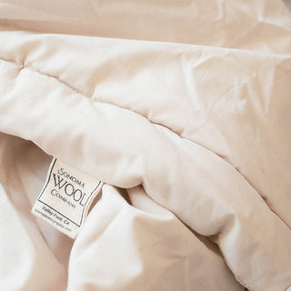 Cozy bed adorned with a soft white comforter, inviting warmth and comfort for restful sleep.