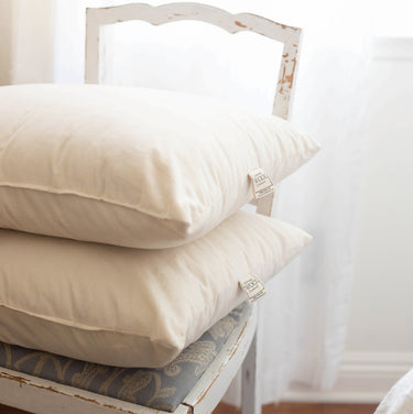 Luxurious organic wool pillows with quality certification tags, showcasing premium sustainable bedding for natural sleep comfort