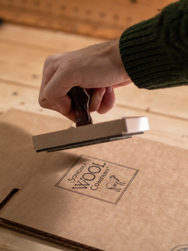 A stamp of Sonoma Wool Company's logo on cardboard.