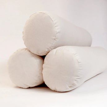 Three Sonoma Wool Company Wool Bolster Pillows stacked in a pyramid against a white backdrop.