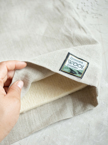 Sonoma Wool Company's Linen Sleeve being lifted up to view the Wool Mat