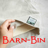 Hand folding a linen sleeve with red Barn Bin lettering over top