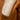 Close up of edge of white wool scarf resting on the shoulder of a leather jacket