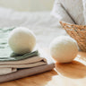 Close up of two wool dryer balls amongst linens