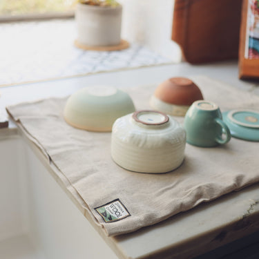 Close-up of wool dish drying mat with stacked bowls