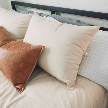 Wool pillow amongst wool bedding and natural textures